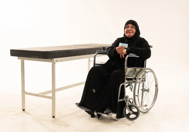 امرأة سعودية مسنة على كرسي متحرك مع دواء