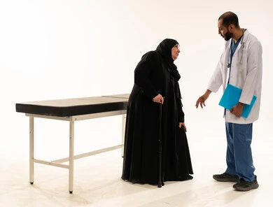 طبيب سعودي يساعد امرأة عربية مسنة في العيادة