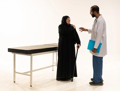 طبيب سعودي يستشير امرأة مسنة في عيادة طبية