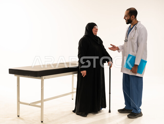 طبيب سعودي يستشير امرأة مسنة في مكتب طبي