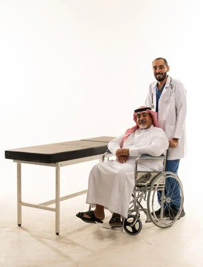 طبيب سعودي مع مريض مسن على كرسي متحرك