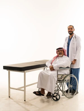 طبيب سعودي مع مريض مسن على كرسي متحرك