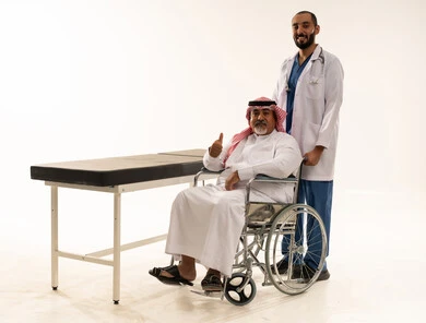 طبيب سعودي مع مريض على كرسي متحرك