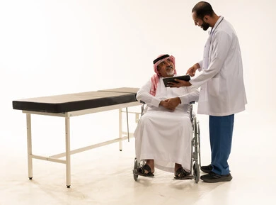 طبيب سعودي مع مريض مسن على كرسي متحرك
