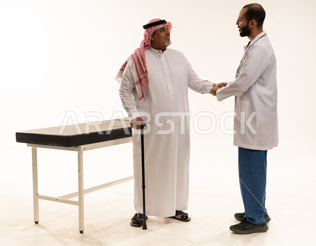 طبيب سعودي يصافح مريض مسن في استوديو طبي