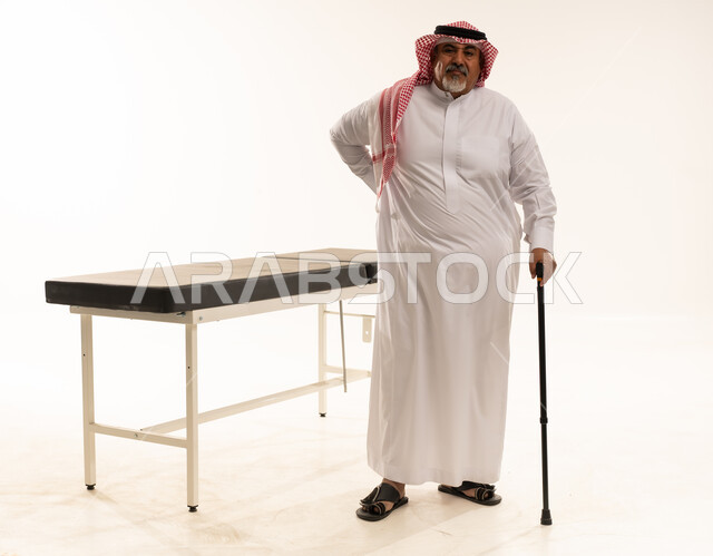 رجل سعودي مسن مع عكاز بجانب طاولة الفحص