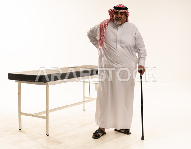 Elderly Saudi Man with Back Pain and Walking Stick