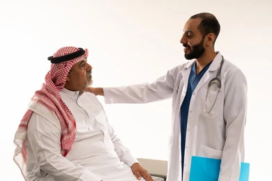 طبيب سعودي يستشير مريضاً مسناً في المستشفى