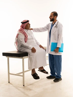 طبيب سعودي مع مريض مسن في عيادة طبية