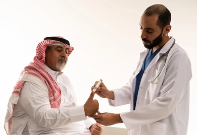 طبيب سعودي يجري فحص السكري لمريض مسن