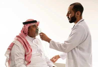 Saudi Doctor Adjusting Oxygen Mask on Elderly Patient