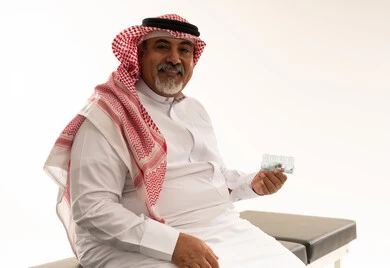 رجل سعودي مسن يحمل منظم حبوب الدواء