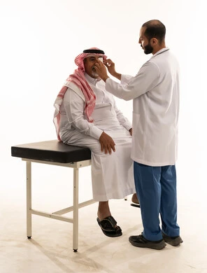 طبيب سعودي يفحص مريضاً مسناً في العيادة