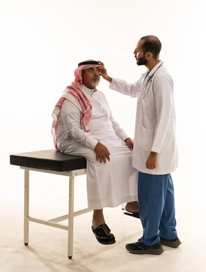 Arab Doctor Examining Elderly Saudi Man in Clinic