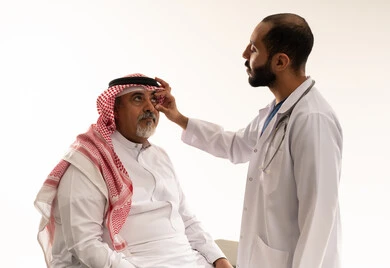 طبيب سعودي يفحص مريض بالزي التقليدي
