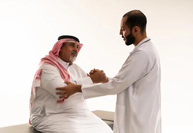 طبيب سعودي يفحص مريضاً مسناً في العيادة