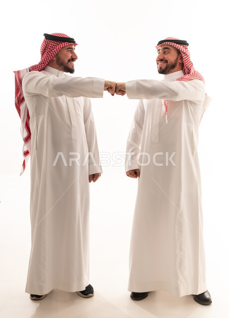 رجال سعوديون بزي تقليدي يقومون بحركة ضرب القبضة