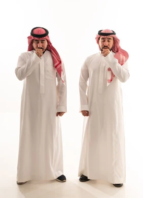 رجال سعوديون بالزي التقليدي يسعلون في استوديو