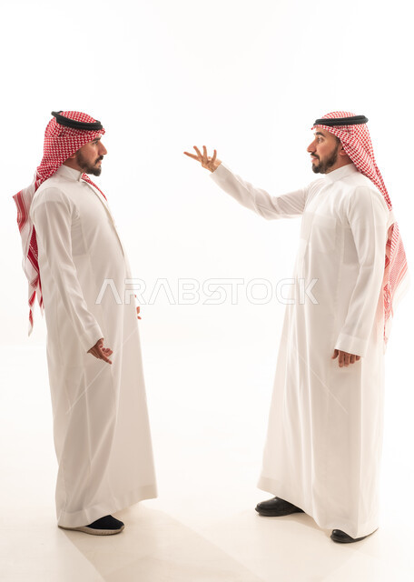 رجال سعوديون بالزي التقليدي في نقاش على خلفية بيضاء