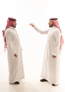 رجال سعوديون بالزي التقليدي في نقاش على خلفية بيضاء