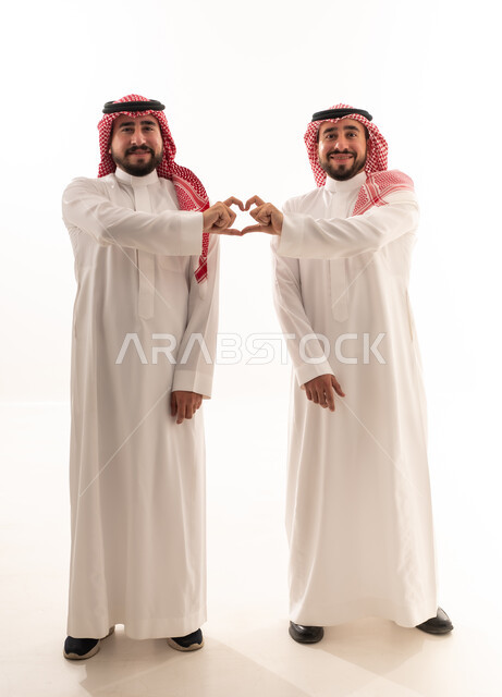 رجلان سعوديان يشكلان رمز القلب بالأيدي