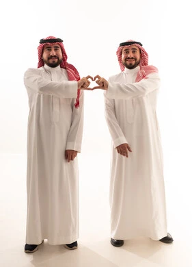 رجلان سعوديان يشكلان رمز القلب بالأيدي