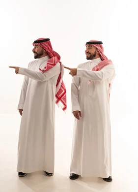 رجلان سعوديان بالزي التقليدي يشيران إلى الجانب