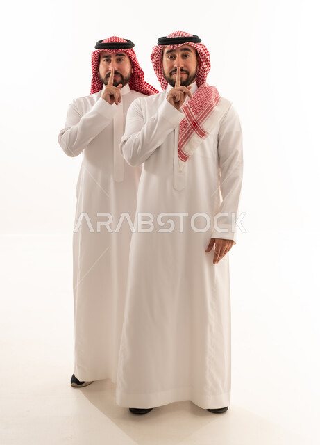 Saudi Men in Traditional Dress Making Silence Gesture