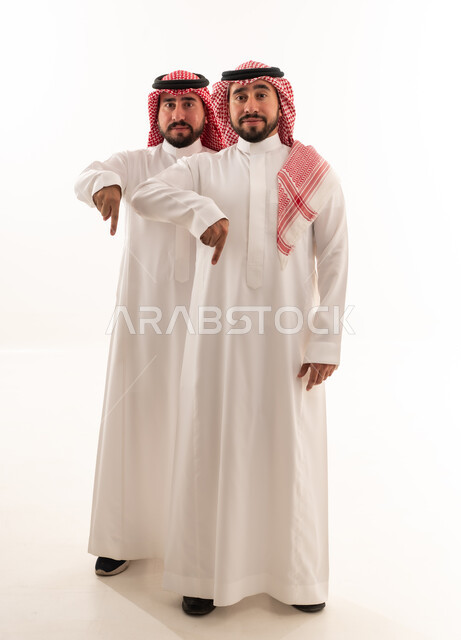 Two Saudi Men Pointing Down in Traditional Dress