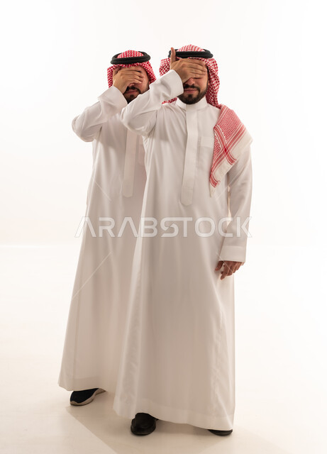 رجلان سعوديان يغطون أعينهم بالزي التقليدي في استوديو