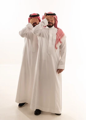 رجلان سعوديان يغطون أعينهم بالزي التقليدي في استوديو