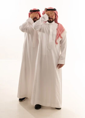 رجلان سعوديان بالزي التقليدي يغطيان أعينهما