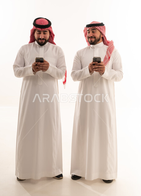 Two Saudi Men Using Smartphones on White Background