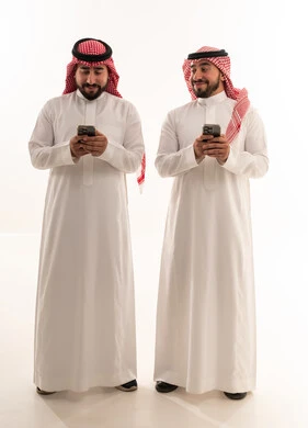 رجلان سعوديان يستخدمان الهواتف الذكية بخلفية بيضاء