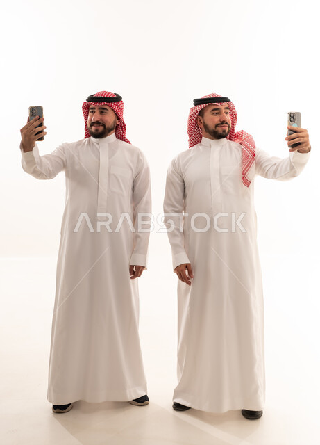 Two Saudi Men in Traditional Thobe Taking Studio Selfies