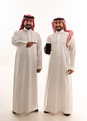 رجال سعوديون بالثوب التقليدي يحملون هاتف ذكي