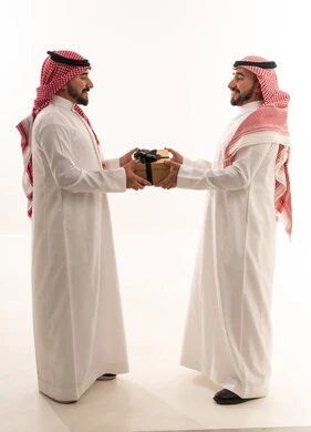 رجال سعوديون يتبادلون الهدايا بالزي التقليدي