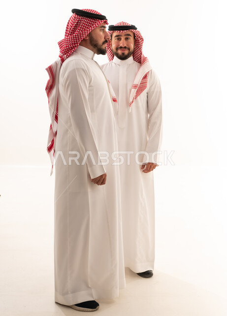 رجلان سعوديان بالزي التقليدي والثوب على خلفية بيضاء