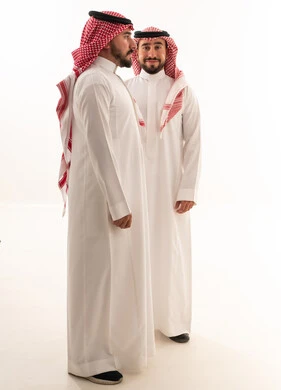 رجلان سعوديان بالزي التقليدي والثوب على خلفية بيضاء