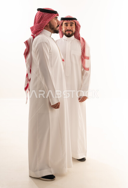 رجلان سعوديان بالزي التقليدي أمام خلفية بيضاء