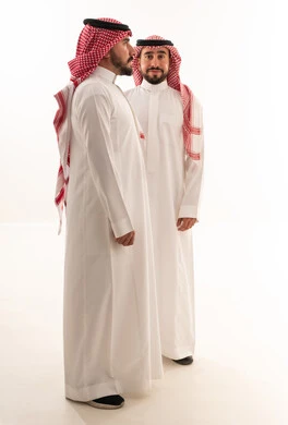 رجلان سعوديان بالزي التقليدي أمام خلفية بيضاء