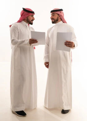 رجال أعمال سعوديون يحملون وثائق ورقية بخلفية بيضاء