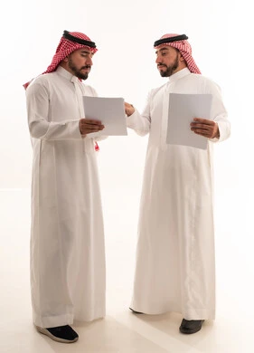 رجال أعمال سعوديون يراجعون مستندات ورقية معاً