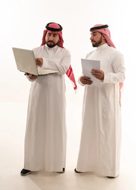 Saudi Businessmen Discussing Data on Laptop Studio Shot