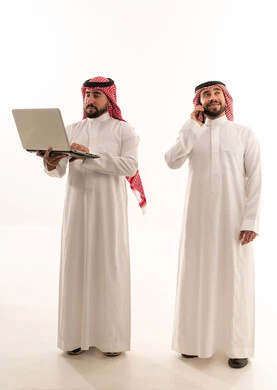 Saudi Businessmen Using Laptop and Mobile Phone