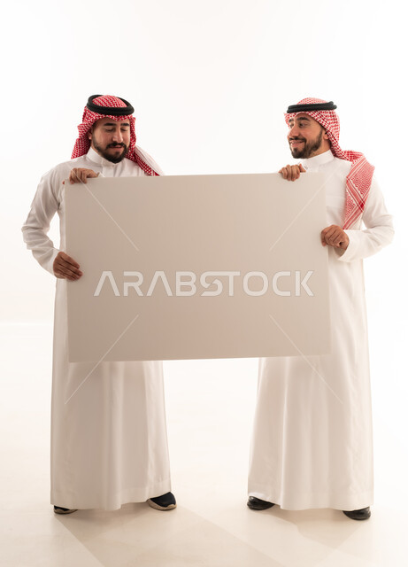 رجلان سعوديان يحملان لوحة بيضاء فارغة للإعلان
