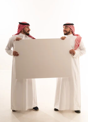 رجلان سعوديان يمسكان بلوحة بيضاء فارغة في الاستوديو