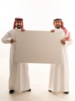 رجال سعوديين يحملون لوحة إعلانية بيضاء فارغة