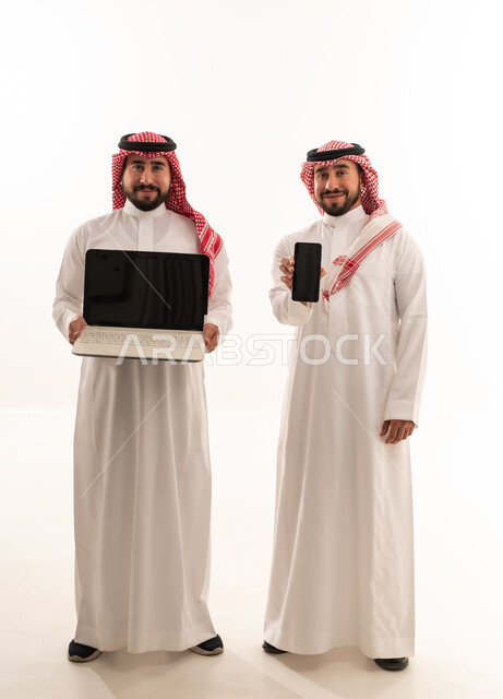 رجال سعوديون مع كمبيوتر محمول وهاتف ذكي خلفية بيضاء