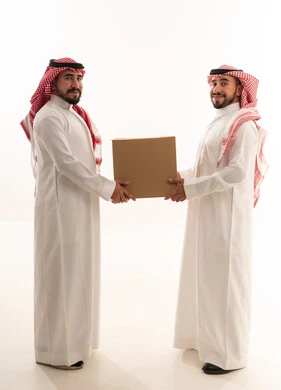 رجال سعوديون يحملون صندوق توصيل كرتوني